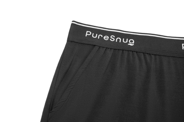 Close-up of black Puresnug lounge short showcasing the elastic waistband with white logo and side pockets.