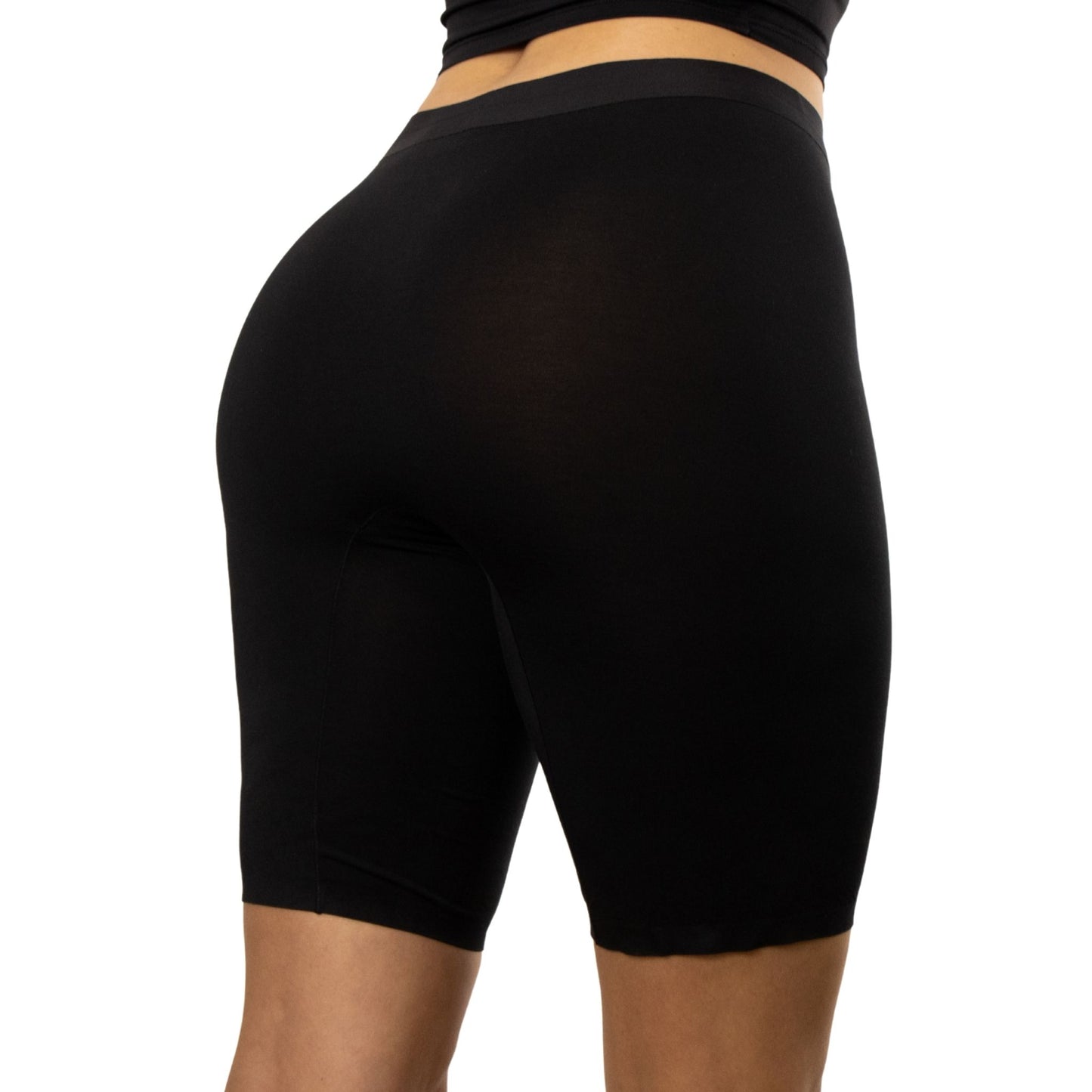 A close-up view of a person wearing PureSnug's black high-waisted biker shorts, highlighting the fabric and fitted style from the back.