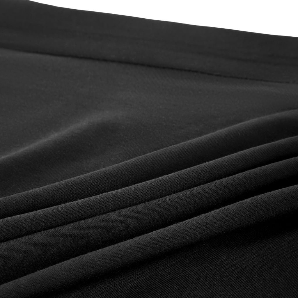 Close-up of soft black fabric with gentle folds, highlighting its smooth texture and rich, deep color.