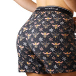 Patterned shorts with bee and flower design on a plain background