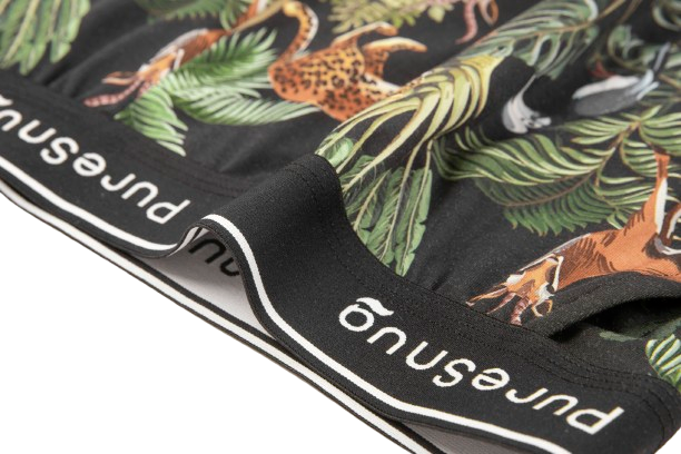 Close-up of women's underwear featuring a vibrant jungle print with animals and plants, showcasing a black waistband labeled "PureSnug"