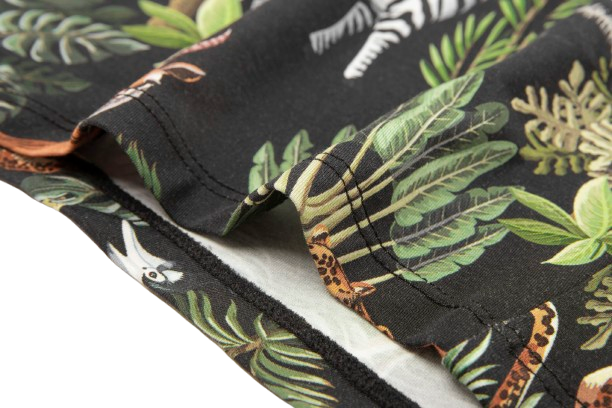 Close-up of a black fabric featuring vibrant jungle-themed prints of leaves and animals like zebras and leopards.