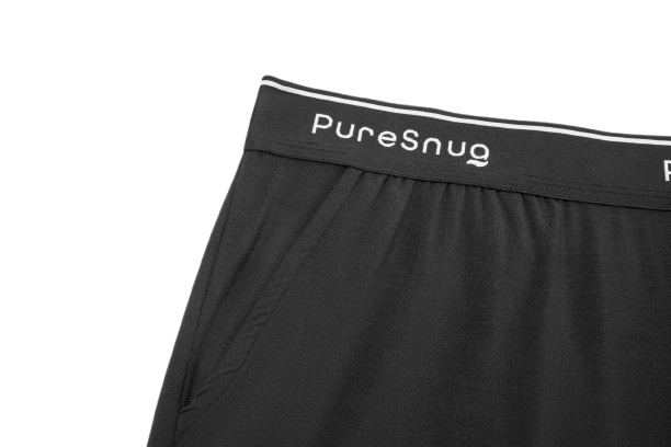 Close-up of black Puresnug lounge short showcasing the elastic waistband with white logo and side pockets. 