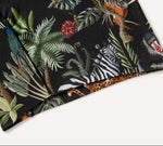 Fabric with vibrant jungle print featuring zebras, leopards, parrots, and lush green foliage against a dark background.