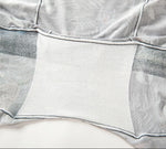Close-up of the inner lining of a white gusset. The fabric features a light gray shade
