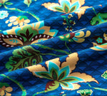 PureSnug blue fabric close-up with bold, colorful floral patterns in yellow, green, and brown.