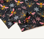 Close-up of PureSnug biker shorts panel with colorful bee & snowflake designs and black trim detailing.