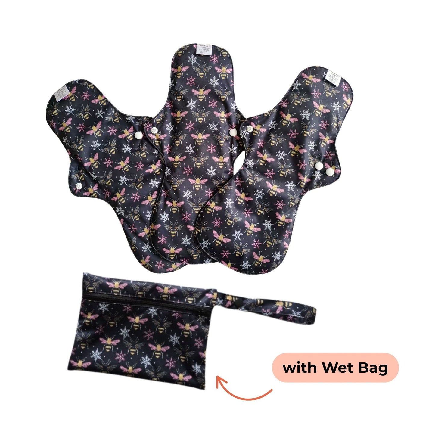 Three reusable night pads with bees and snowflakes patterns are displayed alongside a matching wet bag. 