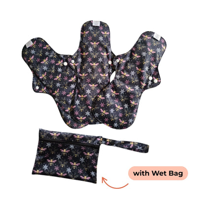 Three reusable night pads with bees and snowflakes patterns are displayed alongside a matching wet bag. 
