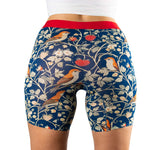 Close-up of woman's fitted boxer shorts featuring a colorful berries and bird print, highlighted by a red waistband.