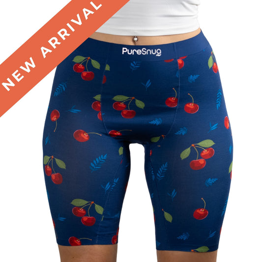 Close-up of PureSnugs High-Waisted 8" Biker shorts with a cherry pattern, featuring a "New Arrival" banner in the corner.