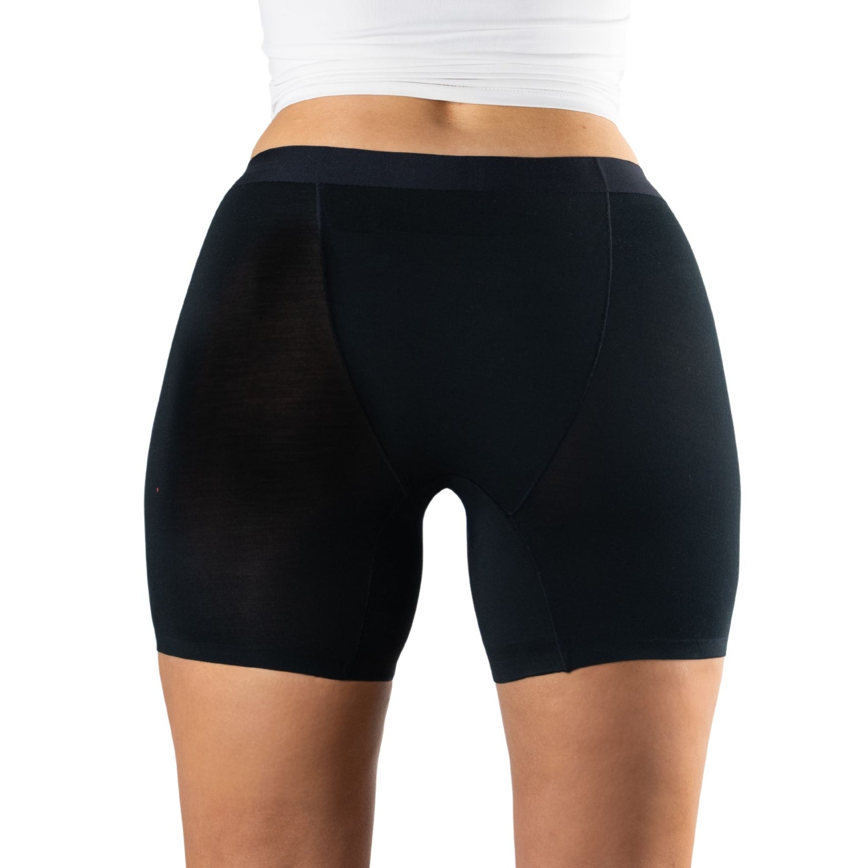 A woman's back view wearing tight black leak proof undies, showcasing a sleek and fitted design, paired with a white top.