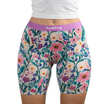 Model wearing Meadow muse floral-patterned PureSnug boxer brief with vibrant pink, yellow, and purple flowers