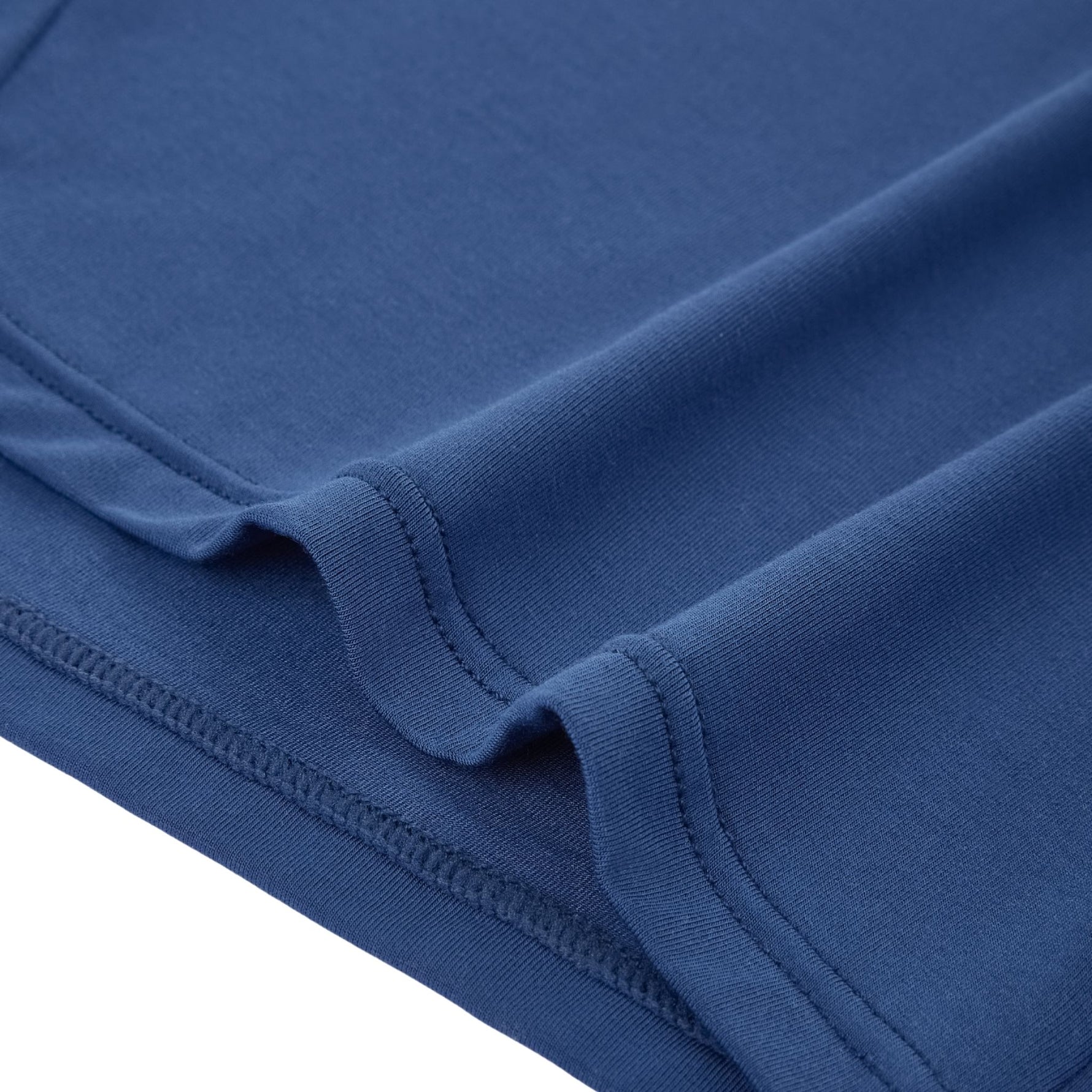 Close-up of the hem on PureSnug navy lounge shorts, showing smooth modal fabric with neat stitching and naturally soft crease