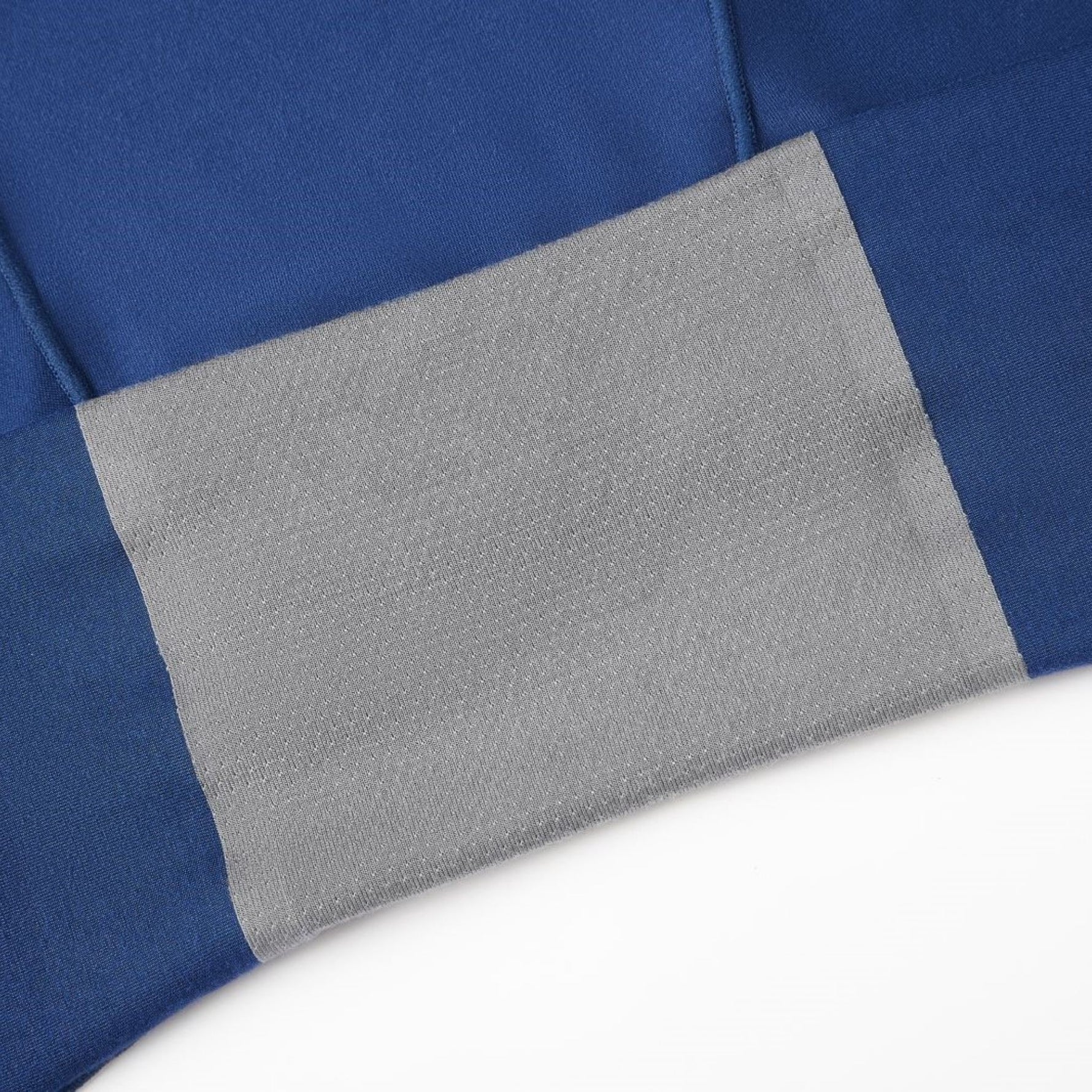 Close-up of soft blue fabric featuring an attached gray gusset.