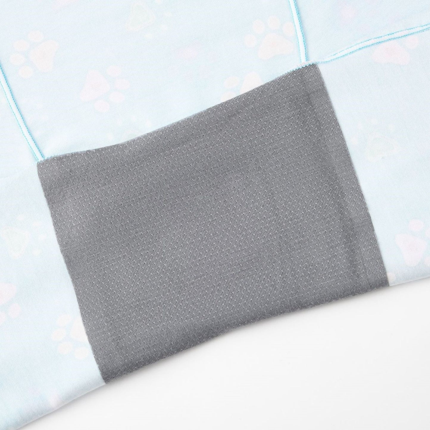 Close-up of  Puresnug Pawfect, a soft, light blue fabric with pastel paw prints, featuring an attached gray gusset for added comfort and style.