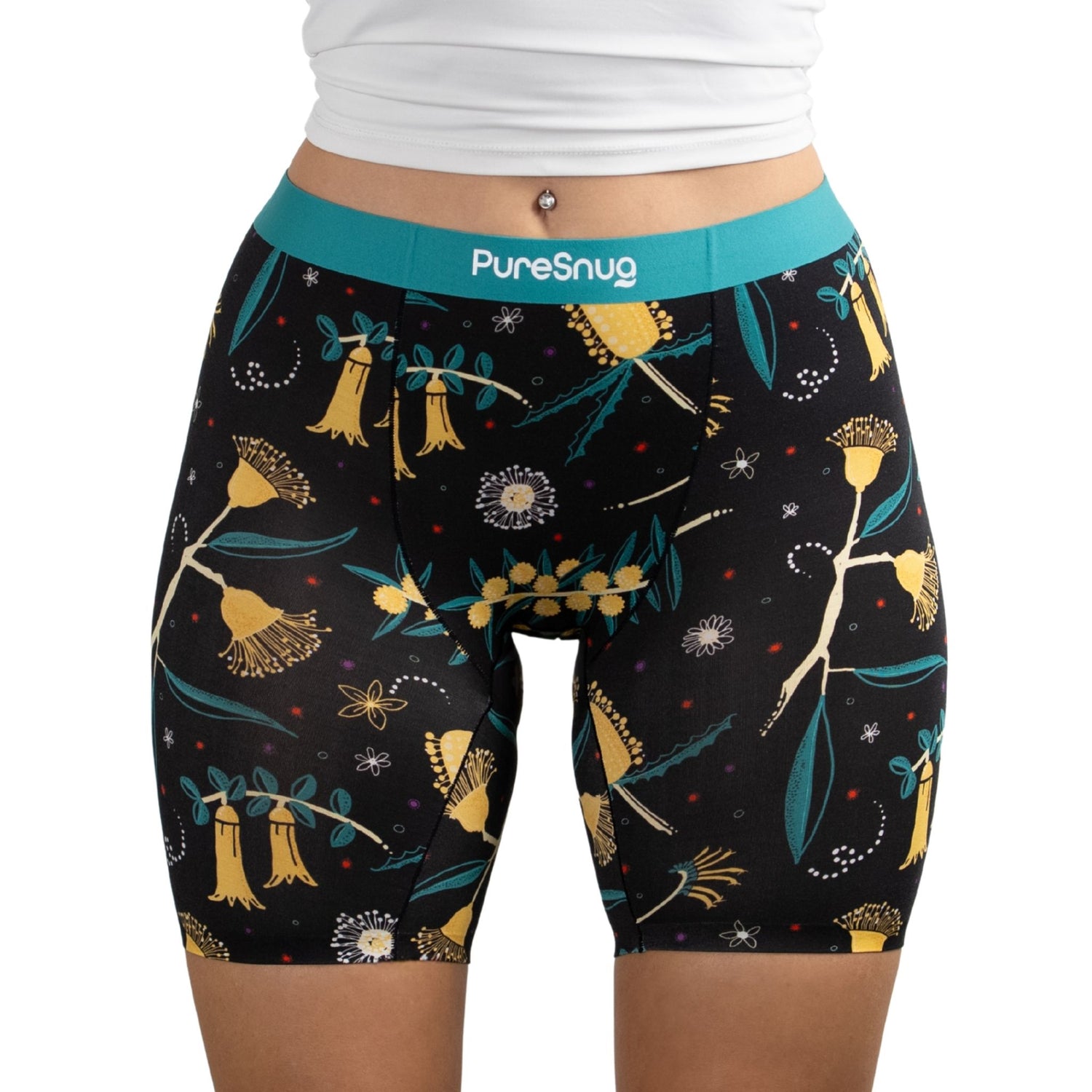 A close-up of a person wearing PureSnug Golden Snug boxer brief in floral-patterned black shorts with a turquoise waistband