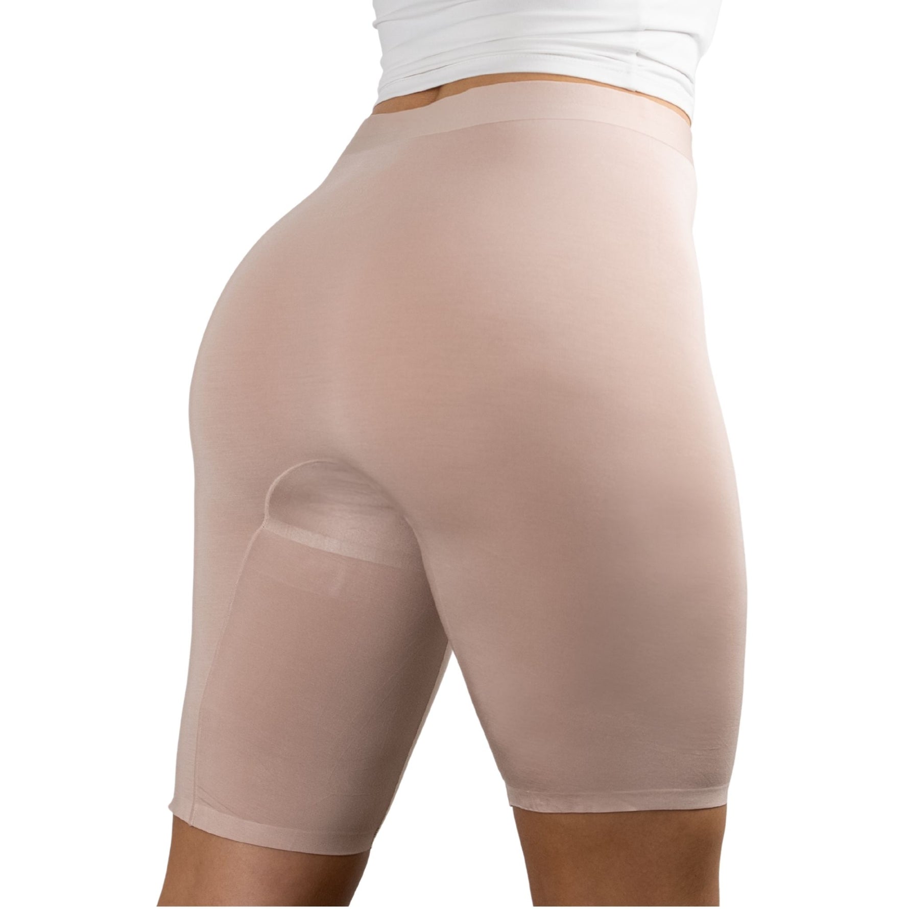 A woman wearing PureSnug high-waisted, nude-colored, seamless shaping shorts, with a white top.