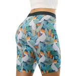 High-waisted shorts with white cockatoo, orange crests, and tropical leaves on a dark background.