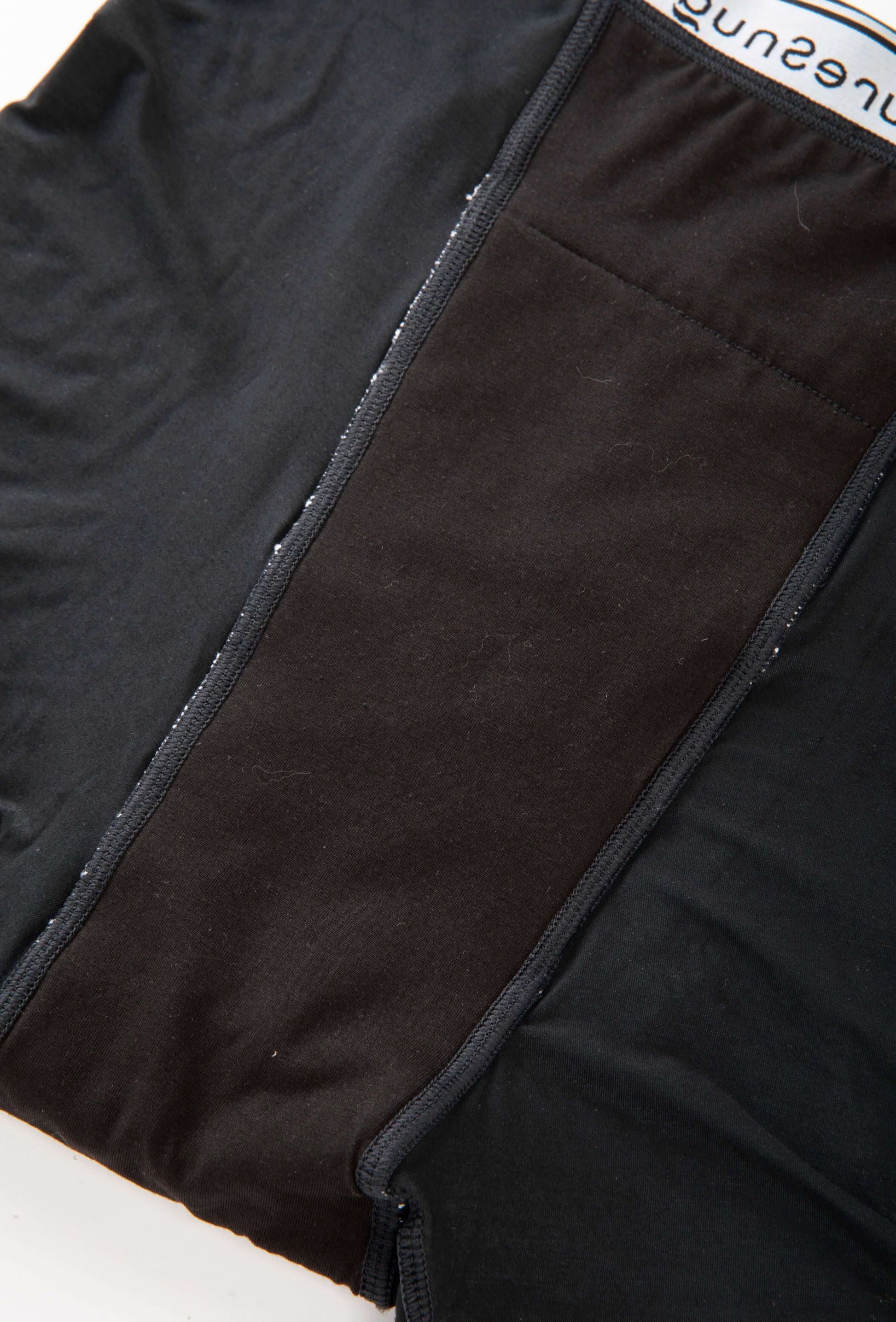 Close-up view of PureSnug period underwear showing the built-in absorbency panel extending from the front to the back waistband.