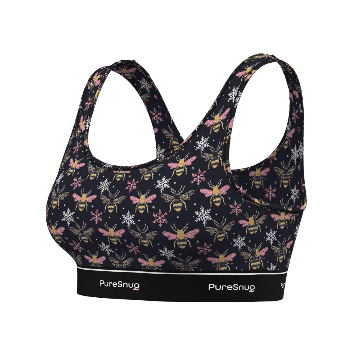 A women's sports bra by PureSnug featuring a dark navy blue base with an all-over print of yellow and black bumblebees, pink flowers, and white snowflakes. The bra has a wide, supportive underband with the brand name 'PureSnug' printed in white.