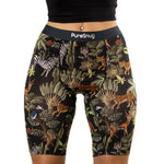 A woman wears black biker shorts with a jungle-themed print featuring zebras, leopards, and tropical leaves.