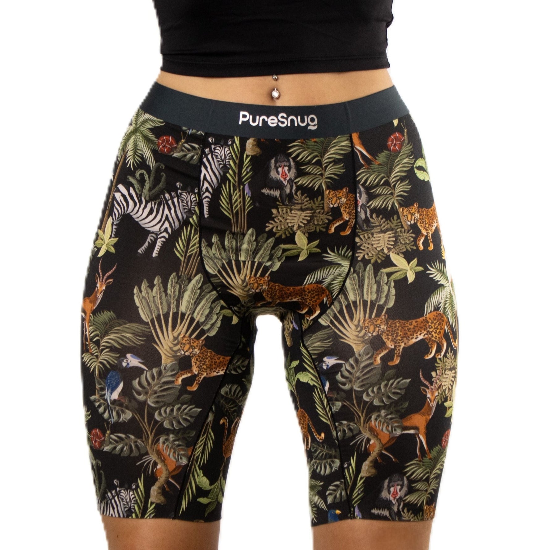 A woman wears black biker shorts with a jungle-themed print featuring zebras, leopards, and tropical leaves.