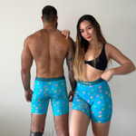 A couple wearing blue floral underwear with paw prints against a plain background.