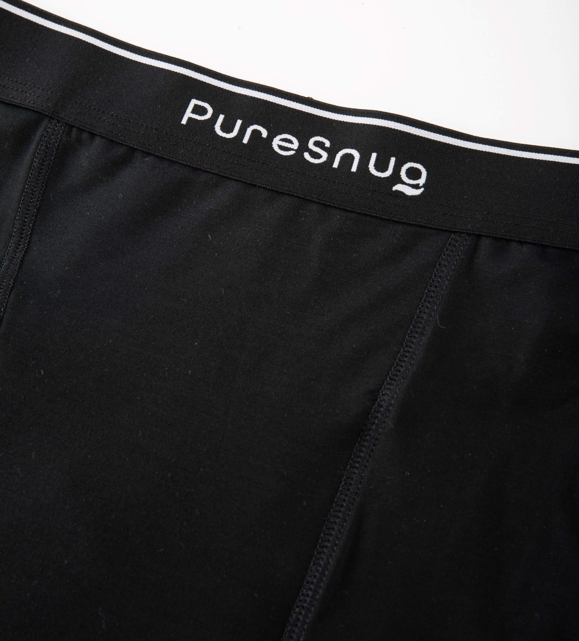 Close-up of Pure Snug’s soft, breathable modal fabric and signature elastic waistband with logo.