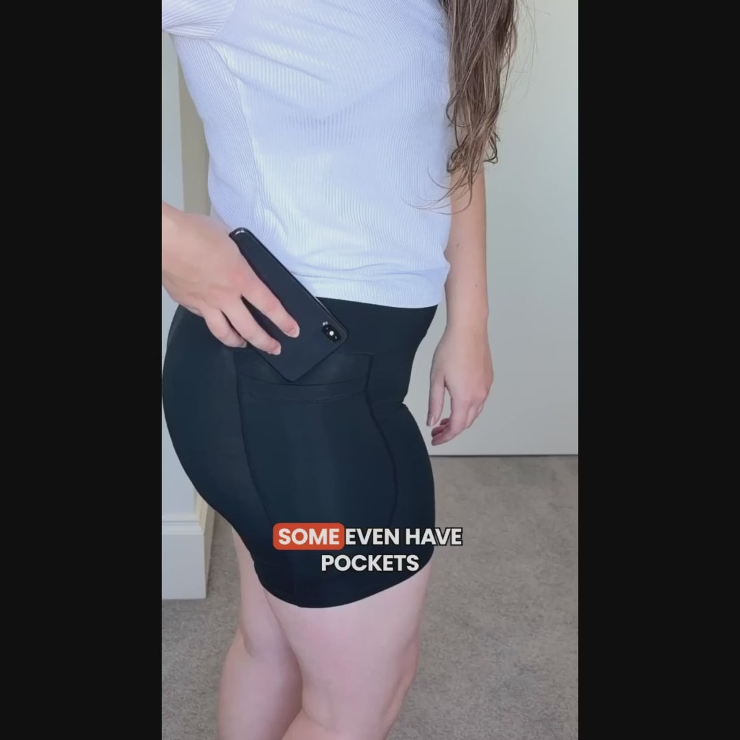 Woman demonstrating the phone pocket on black Pure Snug boxer brief underwear.