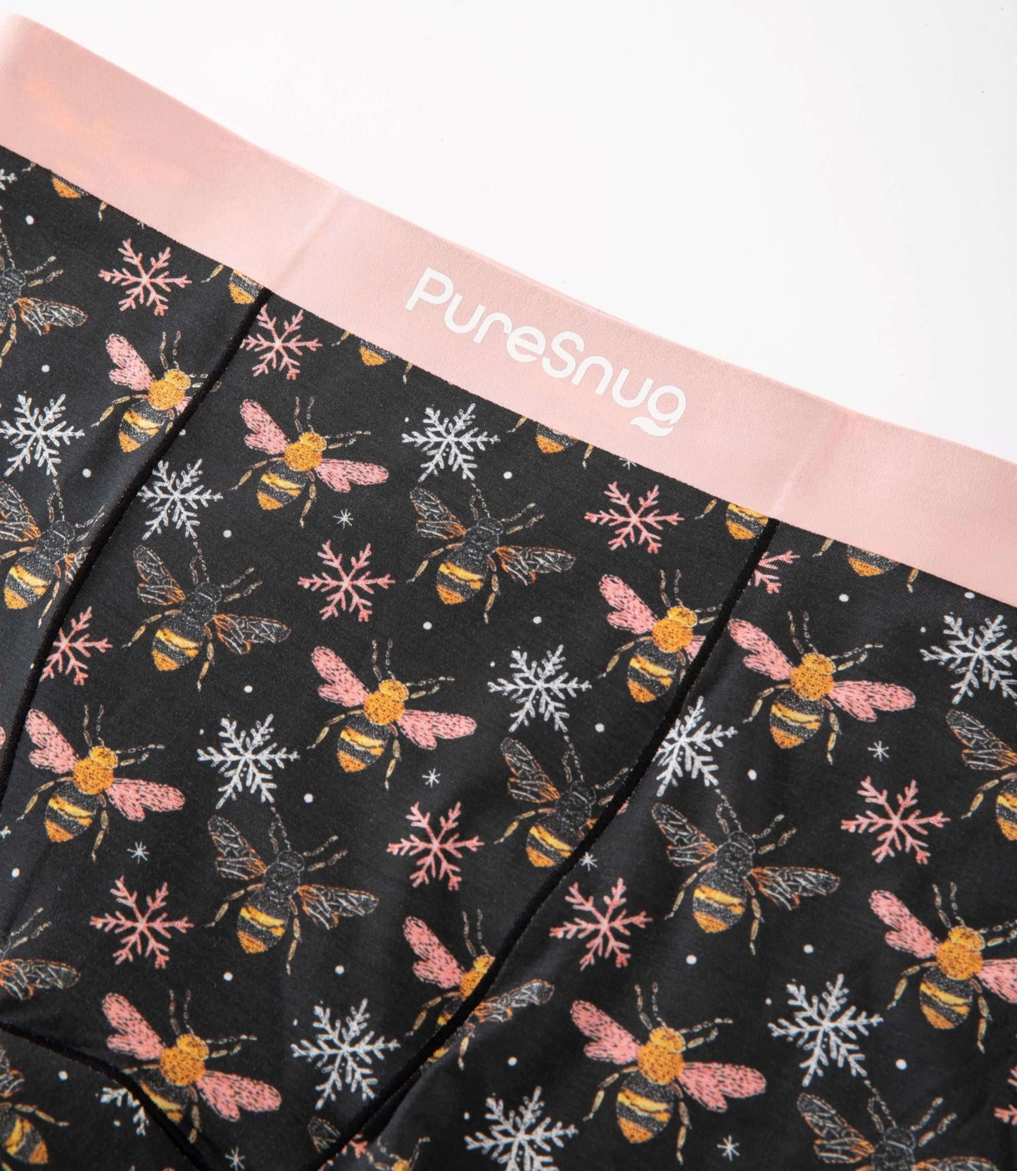 Close-up of PureSnug’s Bees print leakproof underwear featuring a soft pink waistband and breathable modal fabric with a bee and snowflake pattern.