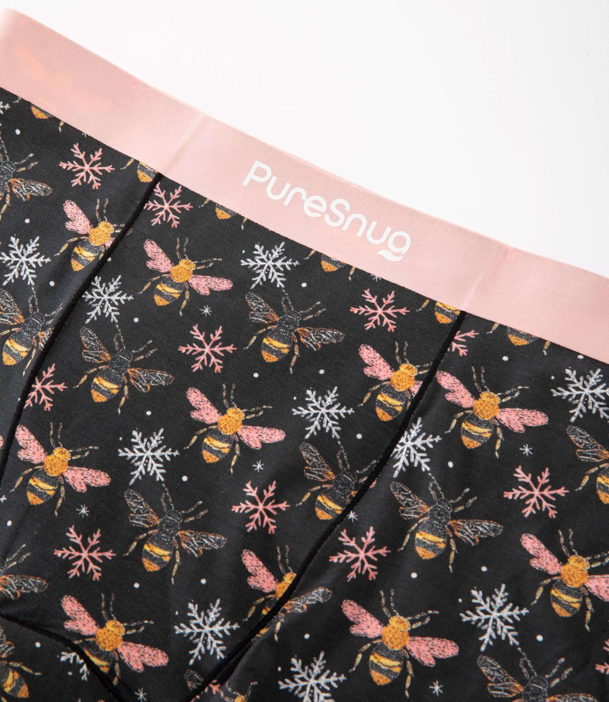 Close-up of PureSnug’s Bees print leakproof underwear featuring a soft pink waistband and breathable modal fabric with a bee and snowflake pattern.